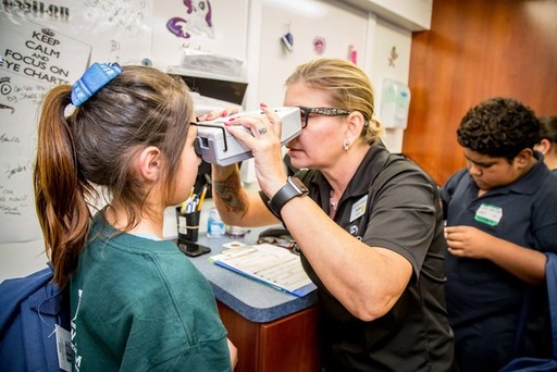 Student receives vision screening from Essilor Vis